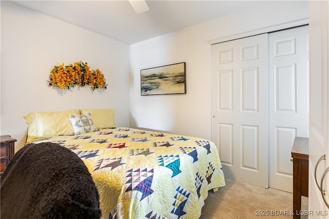 carpeted bedroom with ceiling fan and a closet