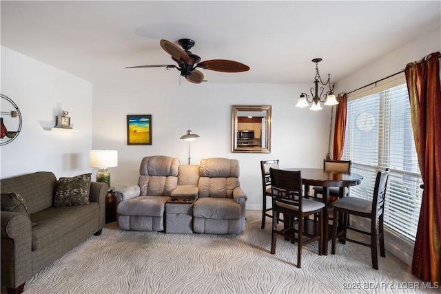 living room with ceiling fan with notable chandelier