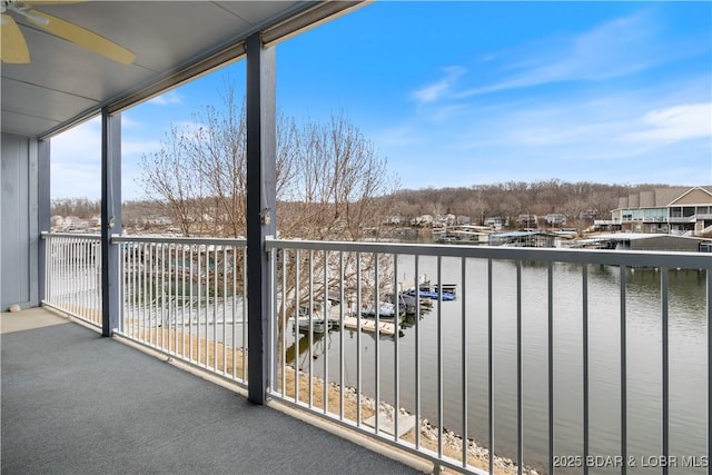 balcony with a water view and ceiling fan