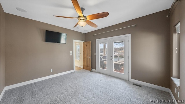 unfurnished room with french doors, ceiling fan, and light carpet