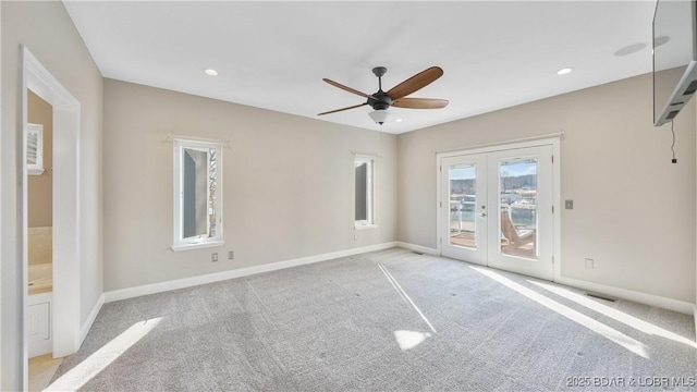 carpeted empty room with french doors and ceiling fan