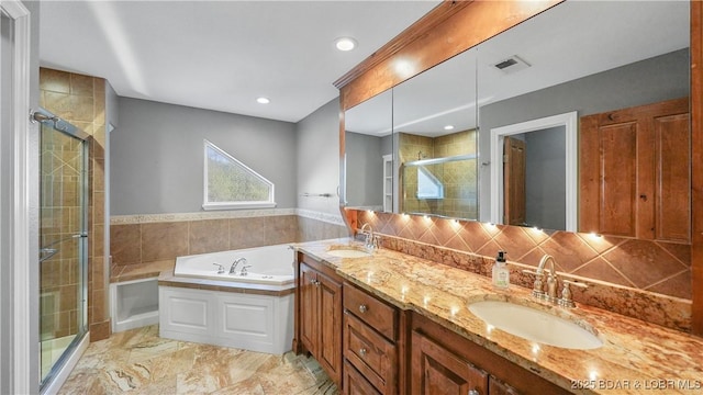 bathroom featuring vanity, shower with separate bathtub, and decorative backsplash