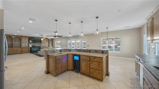 kitchen with ceiling fan, decorative light fixtures, stone counters, and light tile patterned flooring