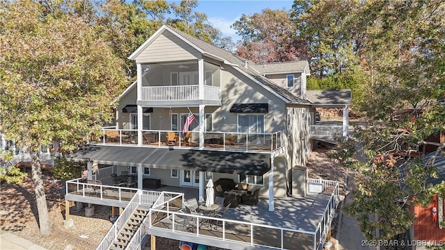 view of front facade featuring a balcony, a deck, and a patio area