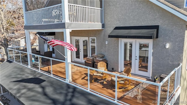 property entrance with a balcony and french doors