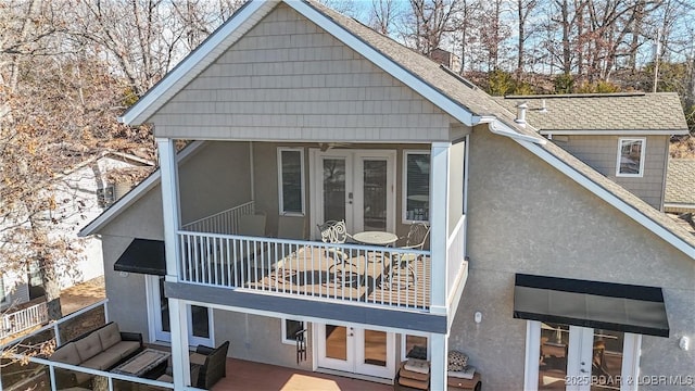 back of house with french doors and a balcony