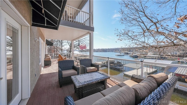 wooden deck with an outdoor living space and a water view