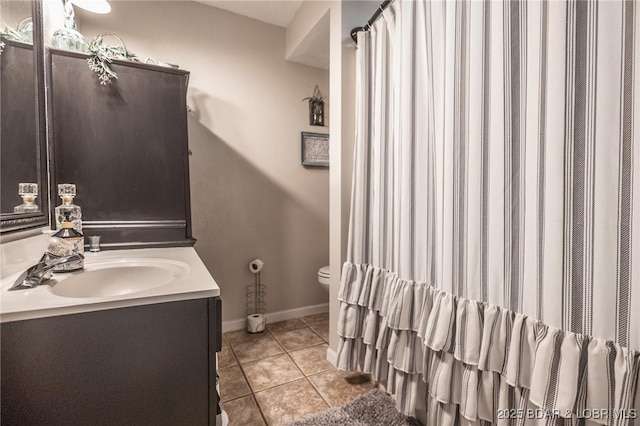 full bath with toilet, tile patterned flooring, vanity, and baseboards