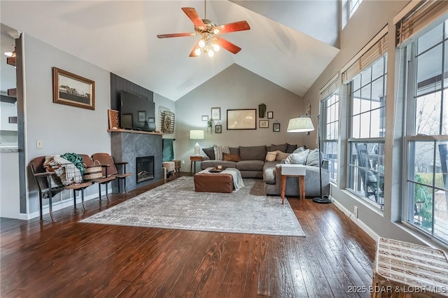 living area with high vaulted ceiling, a fireplace, dark wood finished floors, and baseboards