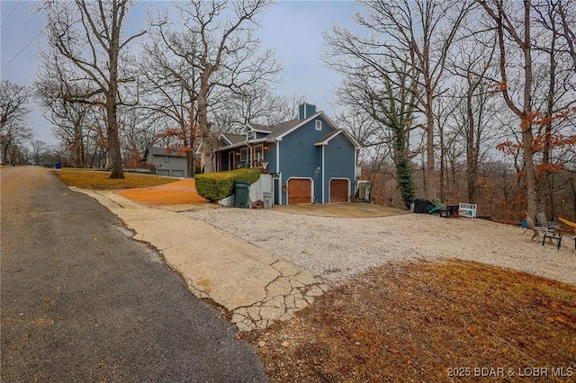 view of front of property featuring driveway and a chimney