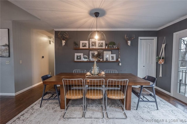 dining space featuring crown molding, baseboards, and wood finished floors