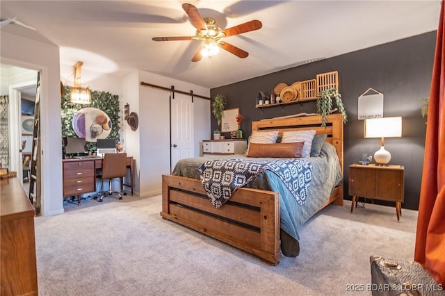 bedroom featuring a ceiling fan, light carpet, and a barn door