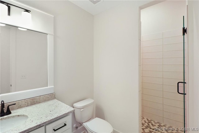 bathroom with vanity, toilet, and a shower with shower door