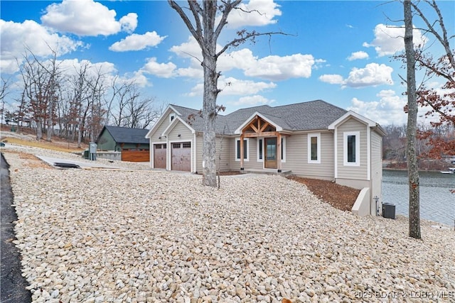 view of front of home with a garage and a water view