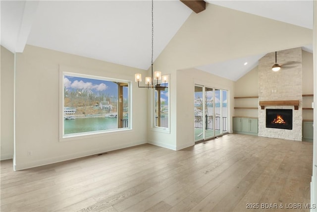 unfurnished dining area with a fireplace, beam ceiling, light hardwood / wood-style flooring, and a healthy amount of sunlight