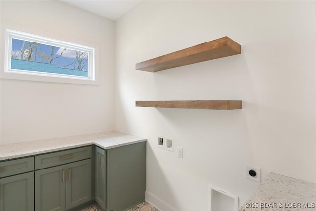 clothes washing area with electric dryer hookup, washer hookup, and cabinets