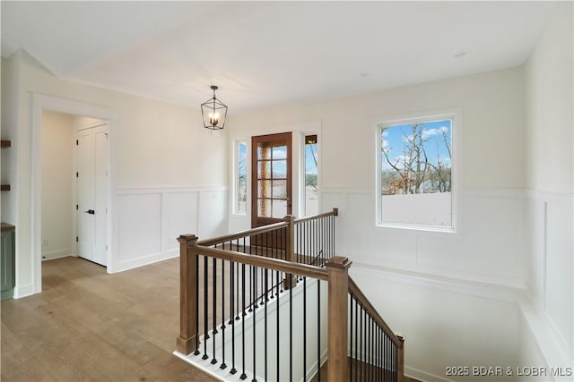 staircase with hardwood / wood-style floors and a chandelier