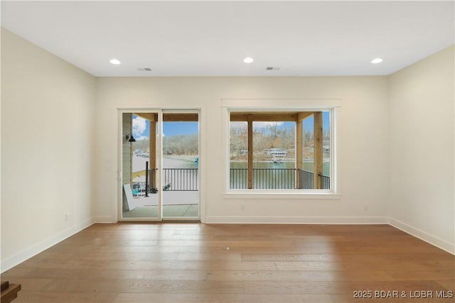 spare room with recessed lighting, baseboards, and wood finished floors