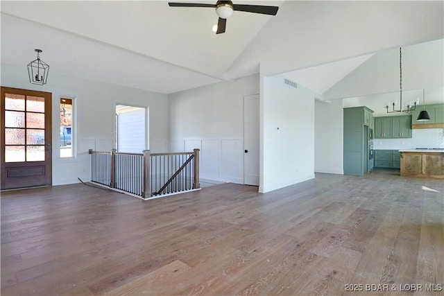 interior space with wood-type flooring, high vaulted ceiling, and ceiling fan