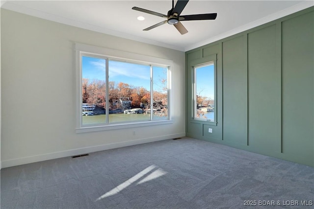 carpeted spare room featuring ornamental molding and ceiling fan