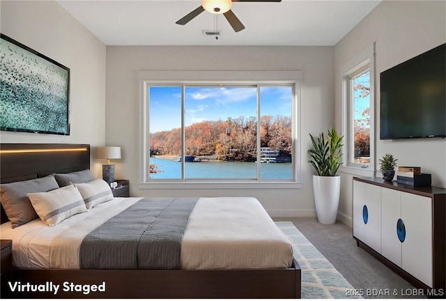 carpeted bedroom with a ceiling fan, visible vents, and baseboards