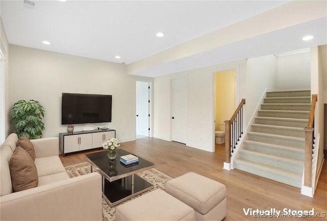 living area with light wood-style flooring, recessed lighting, and stairway