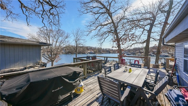 deck with a water view and a grill