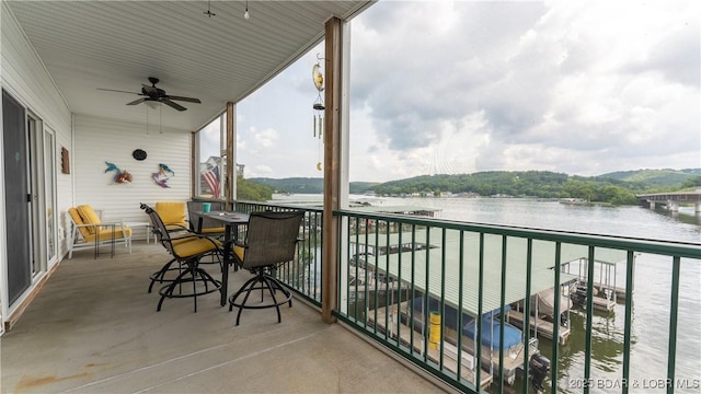 balcony featuring a water view and ceiling fan