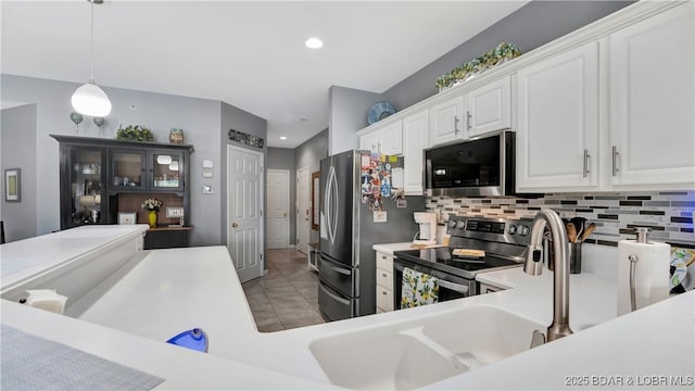 kitchen featuring light tile patterned floors, appliances with stainless steel finishes, white cabinets, pendant lighting, and backsplash