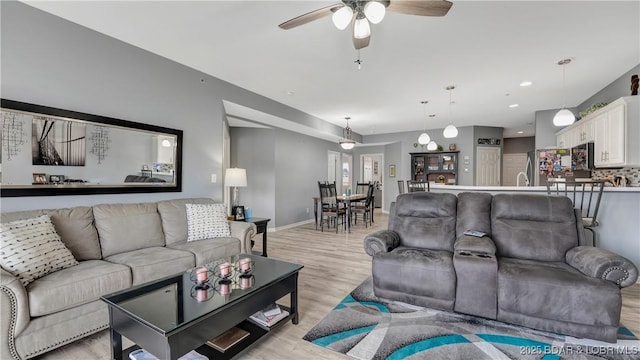 living room with light hardwood / wood-style flooring and ceiling fan