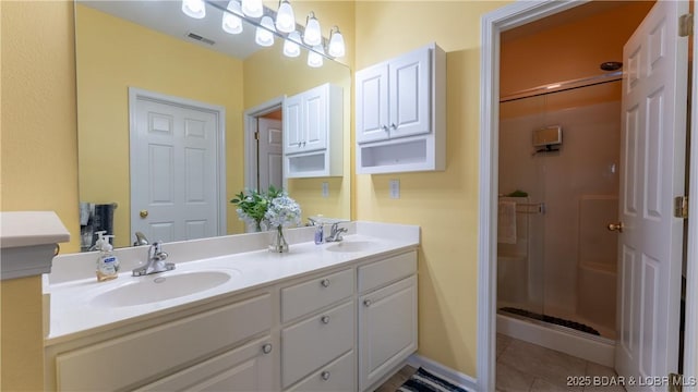 bathroom with tile patterned flooring, vanity, and a shower with shower door