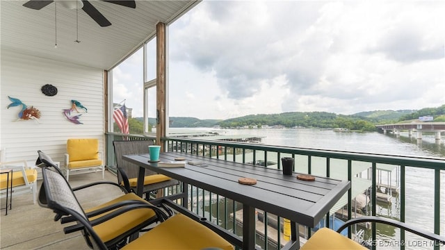 balcony featuring ceiling fan and a water and mountain view