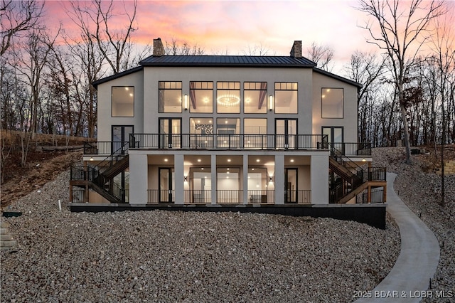 back house at dusk with a balcony