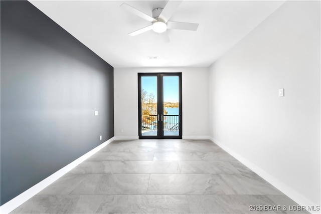 spare room featuring ceiling fan and french doors