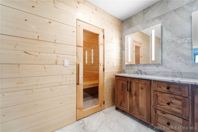 bathroom featuring vanity and wooden walls