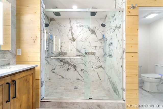 bathroom with vanity, a shower with shower door, toilet, and wood walls