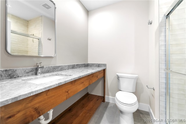 bathroom featuring tile patterned flooring, vanity, an enclosed shower, and toilet