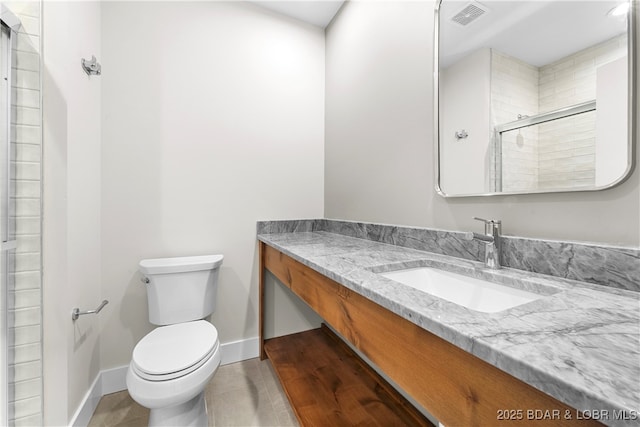 bathroom with vanity, toilet, a shower with shower door, and tile patterned flooring