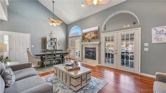 living room with french doors, ceiling fan, dark hardwood / wood-style floors, and high vaulted ceiling