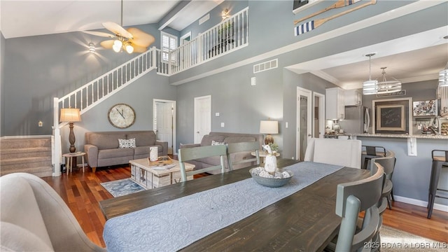 dining room with crown molding, ceiling fan, dark hardwood / wood-style flooring, and high vaulted ceiling