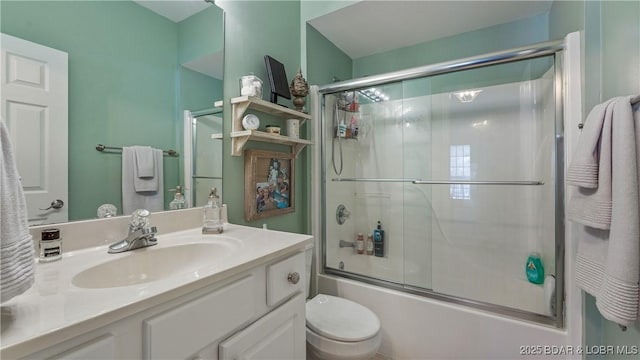 full bathroom with vanity, shower / bath combination with glass door, and toilet