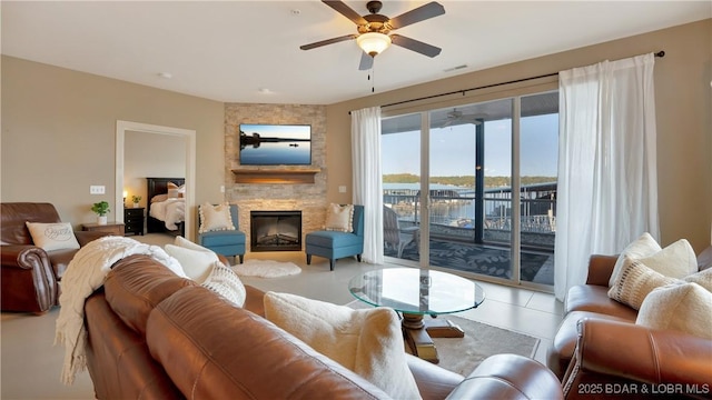 living room featuring a stone fireplace and ceiling fan