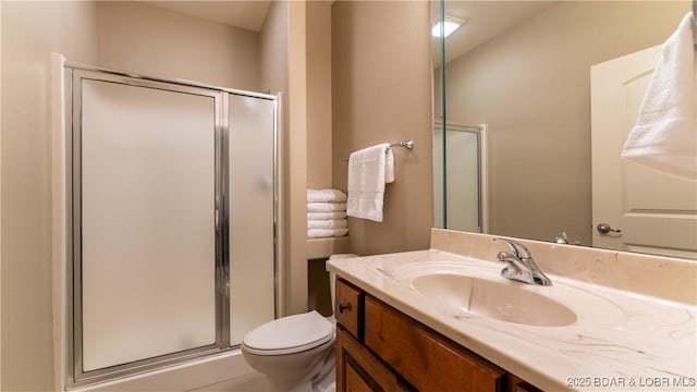 bathroom featuring an enclosed shower, vanity, and toilet