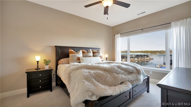 bedroom with a water view, light carpet, lofted ceiling, and ceiling fan