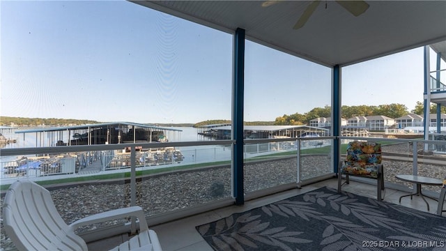 sunroom featuring a water view and ceiling fan