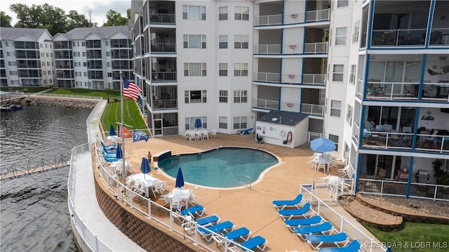 view of swimming pool featuring a water view and a patio area