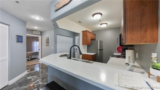 kitchen with sink, stainless steel fridge, and kitchen peninsula