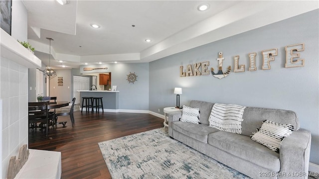 living room with an inviting chandelier and dark wood-type flooring