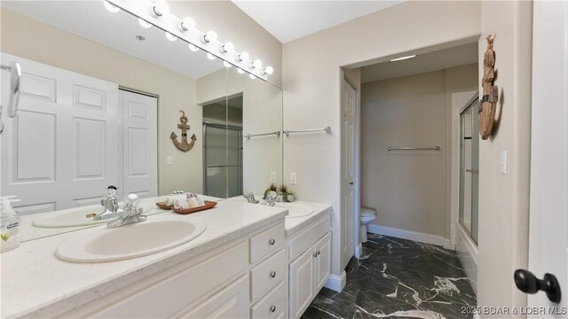 full bathroom with vanity, combined bath / shower with glass door, and toilet