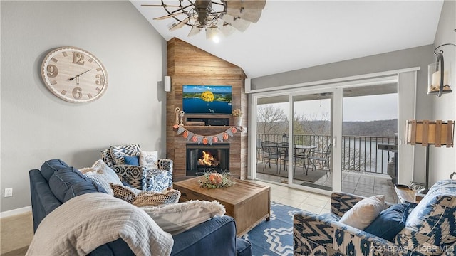 living room with ceiling fan, a fireplace, vaulted ceiling, and light tile patterned floors